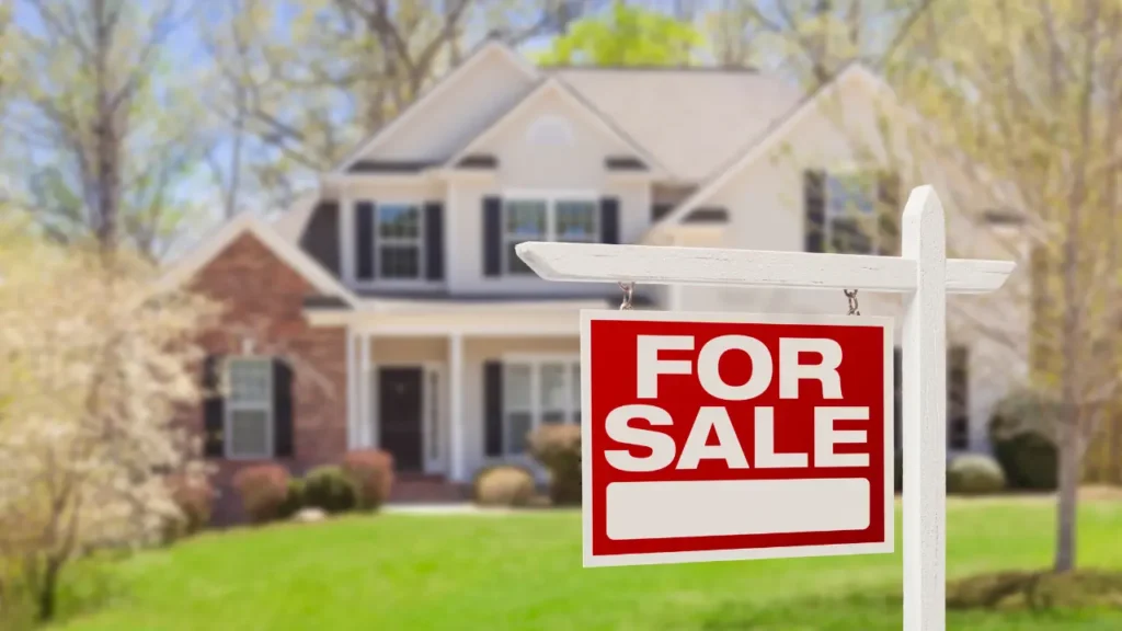 Home with for sale sign in front yard