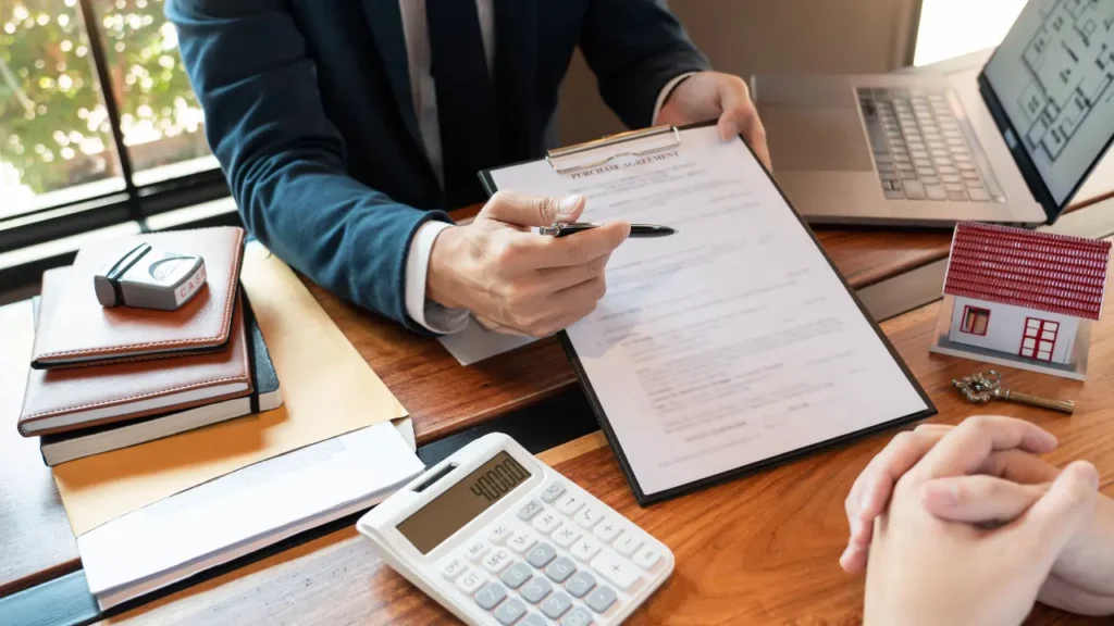 person presenting purchase agreement over desk